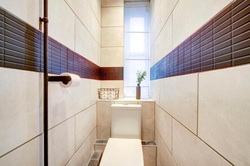 a bathroom with a toilet and a window at BRICK LANE APARTMENT in London