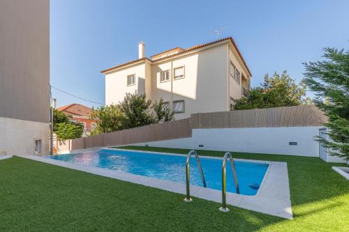 a swimming pool in front of a house at StudentVille Academia in Coimbra