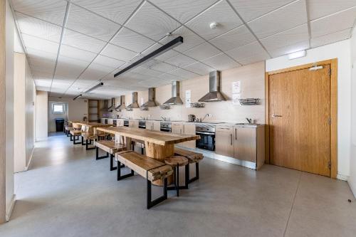 a large room with a long table and a kitchen at StudentVille Academia in Coimbra