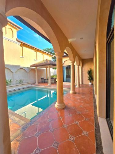 a swimming pool in the middle of a house at Nusa chivani pool villa najomtien with 4 bedrooms ณุศา ชิวานี พลูวิลล่า 4 ห้องนอน นาจอมเทียน in Na Jomtien