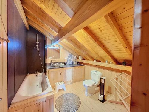 a bathroom with a toilet and a bath tub at Chalet de standing 14 personnes in Gérardmer