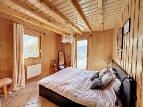 ein Schlafzimmer mit einem Bett in einem Zimmer mit Holzwänden in der Unterkunft Chalet de standing 14 personnes in Gérardmer
