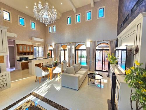 a large living room with a couch and a table at Nusa chivani pool villa najomtien with 4 bedrooms ณุศา ชิวานี พลูวิลล่า 4 ห้องนอน นาจอมเทียน in Na Jomtien