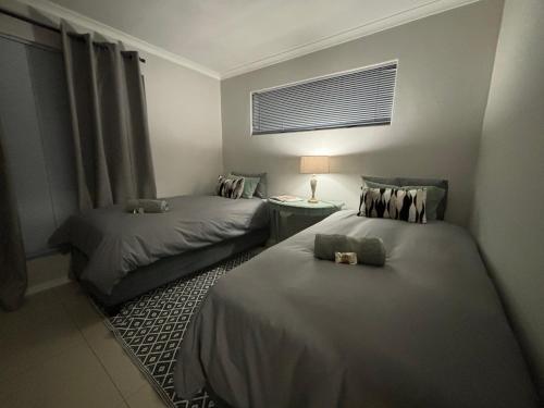 a hotel room with two beds and a window at Tyger Valley Villa in Durbanville