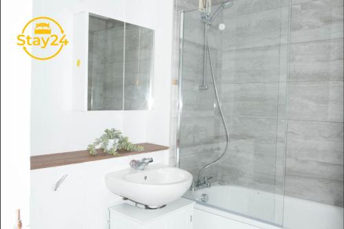 a white bathroom with a sink and a shower at Penryn place in Milton Keynes
