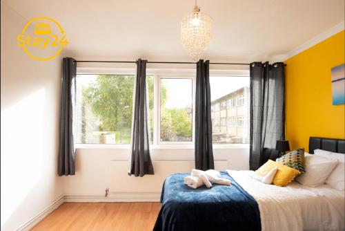 a bedroom with a bed and a large window at Penryn place in Milton Keynes
