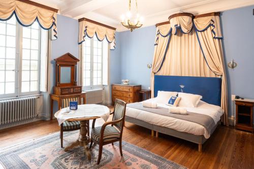 a bedroom with a bed and a table and chairs at Château de Servanes in Mouriès