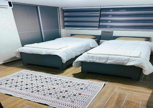 a room with two beds and a rug on the floor at kirakoupolis House & Restaurant in Kerak