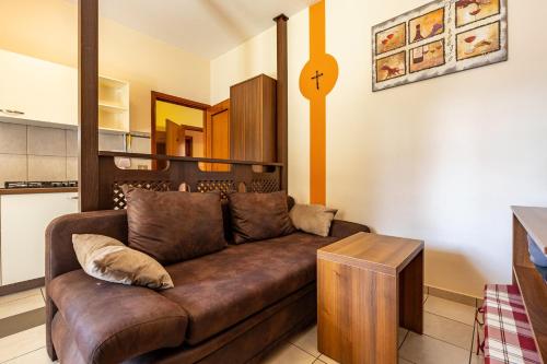 a living room with a brown couch in a kitchen at Appartamento Alexander in Tignale