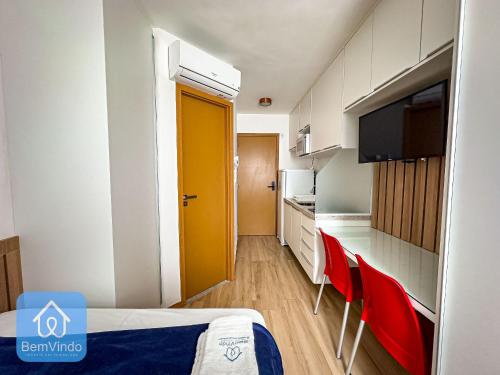 a room with a kitchen with a yellow door at Estadia Confortável: Studio no Smart Pituba in Salvador