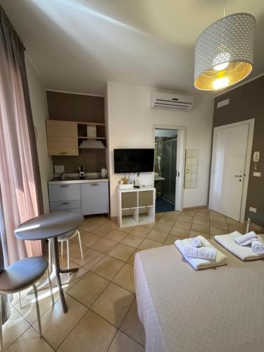 une chambre avec un lit et des chaises ainsi qu'une cuisine dans l'établissement San Pietro Otranto, à Otrante