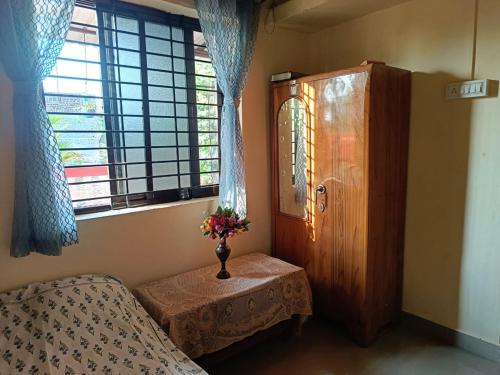 una camera con letto, tavolo e finestra di Kittur Guest House a Dharwad