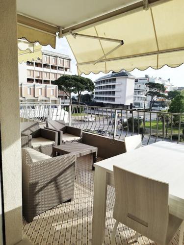 a balcony with tables and chairs and an umbrella at PhotoWalkTour House in Lido di Jesolo