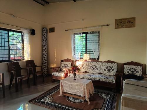 sala de estar con sofá y mesa de centro en Kittur Guest House, en Dharwad