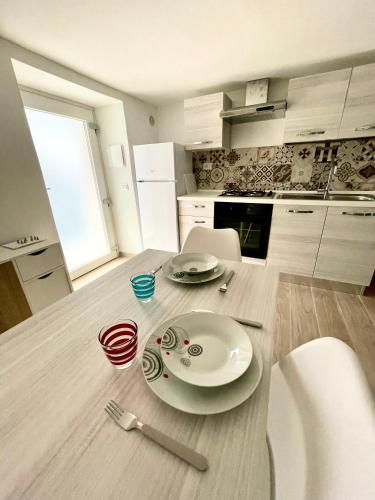 a kitchen with a table with plates and utensils on it at A Casucc appartamenti in Peschici