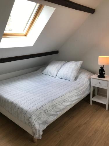 a bedroom with a white bed with a window at Appartement coquet dans maison individuelle in Lisses