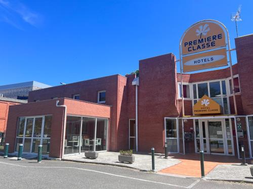 un bâtiment avec un panneau indiquant un hôtel dans l'établissement Premiere Classe Toulouse Sud Labege, à Labège