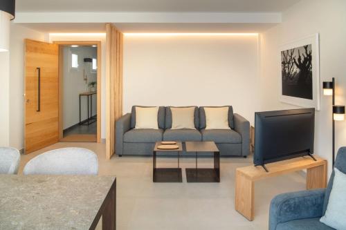 sala de estar con sofá y TV en Panasco Suites, en Arrecife