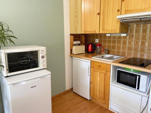 une petite cuisine avec un micro-ondes et un évier dans l'établissement CELADON - Studio, Rez-de-Jardin, Proche Plage - U205, à Carnac