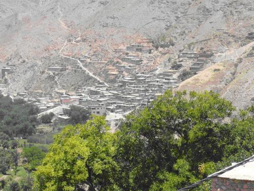 a village on a mountain with trees and houses at MAROC LODGE Atlas Mountain Retreat in Amizmiz