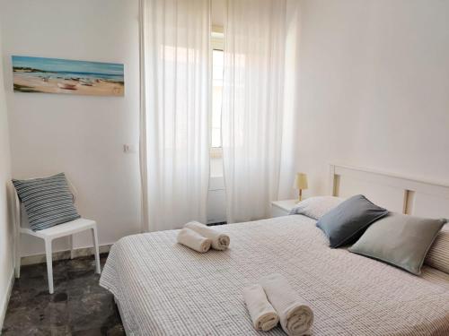 a white bedroom with two beds with towels on them at Casa Atena in Sperlonga