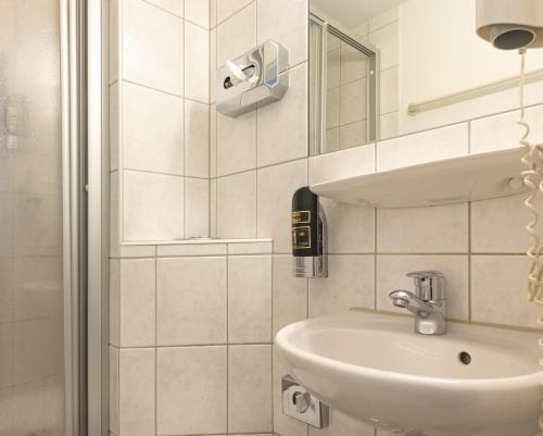 uma casa de banho branca com um lavatório e um espelho em Gasthaus Traube, Ludwigshafen, Bodensee, Seenah gelegen em Bodman-Ludwigshafen