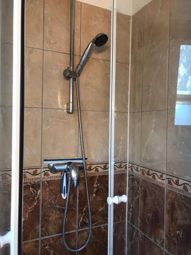une douche dans une salle de bain avec une pomme de douche dans l'établissement Appartement coquet dans maison individuelle, à Lisses