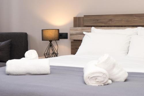 a hotel room with a bed with towels on it at Lorien City Center Apartments in Ioannina