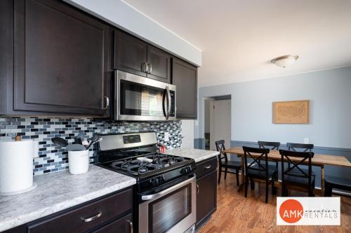a kitchen with black cabinets and a stove top oven at Holland Hideaway in Holland