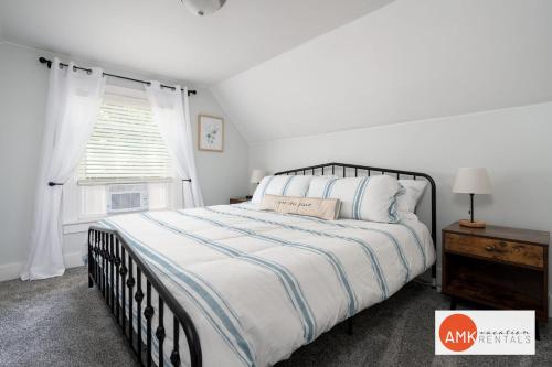 a white bedroom with a large bed and a window at Holland Hideaway in Holland