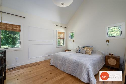 a bedroom with a bed and two windows at Beautiful Custom Lake House in Holland