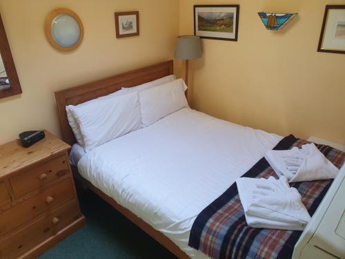 a bedroom with a bed with white sheets and towels at Rose Cottage, Meathop Grange in Grange Over Sands