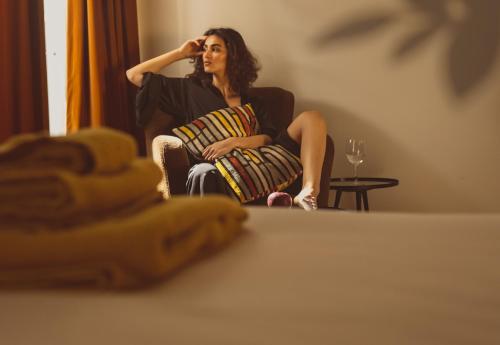 a woman sitting in a chair looking in a mirror at Bugan-Villa in Athens