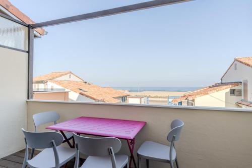 卡布勒通的住宿－Atlantic Selection - Vue Océan avec terrasse, plage Notre-Dame，阳台配有粉红色的桌椅