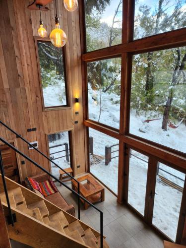 a staircase in a cabin with a view of the snow at Lodge Rincon del Bosque, Malalcahuello in Malalcahuello