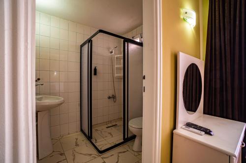 y baño con ducha, aseo y lavamanos. en DE MARE FAMILY Hotel, en Konaklı