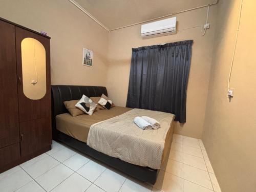 um pequeno quarto com uma cama e uma janela em Citadil Homestay em Miri