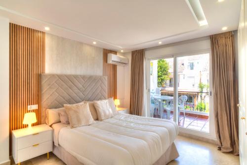 ein Schlafzimmer mit großem Bett und Balkon in der Unterkunft Serenity Luxury , Puerto Banús Marbella in Marbella