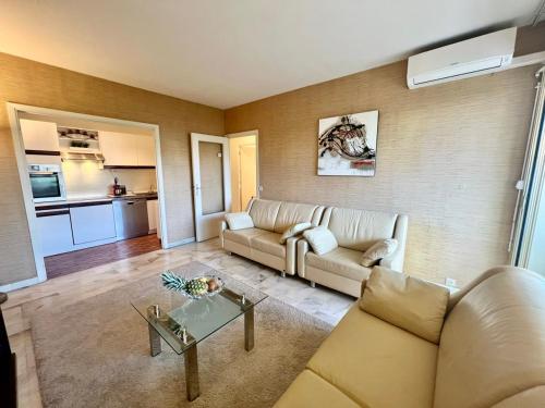 un salon avec un canapé et une table dans l'établissement B038 Spacieux Appartement proche Croisette parking, à Cannes