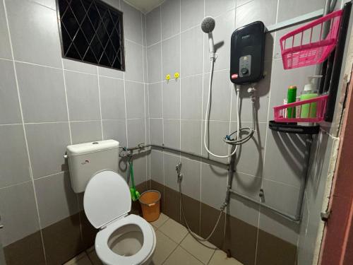 y baño pequeño con aseo y ducha. en Citadil Homestay, en Miri