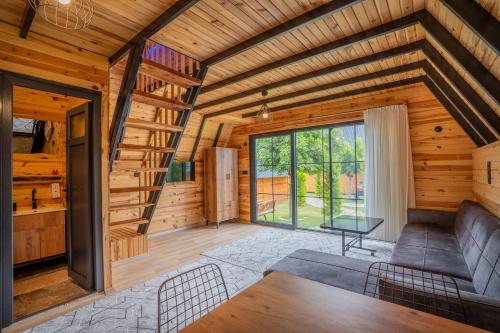 a living room with a staircase in a wooden house at Karaöz Sapphire Bungalows in Kumluca