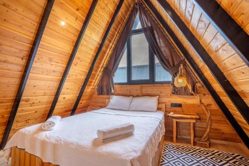 uma cama num quarto de madeira com uma janela em Karaöz Sapphire Bungalows em Kumluca
