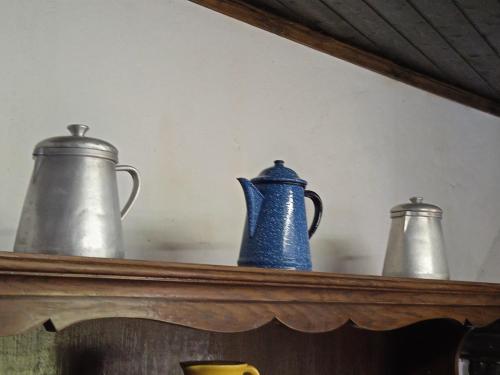 three vases sitting on top of a shelf at Casa Pintarolas in Lousã
