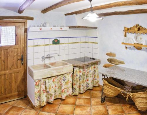 uma cozinha com um lavatório e um balcão em Casa Rural La Curiosa em Laroya