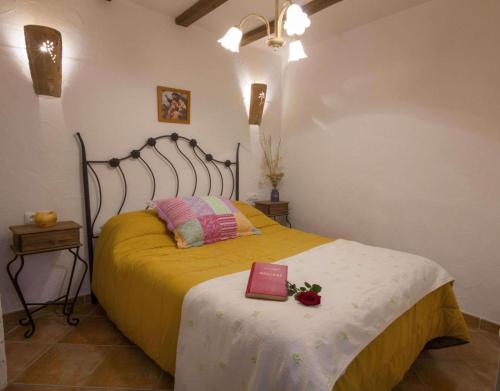 a bedroom with a bed with a book on it at Casa Rural Padre Ramon in Laroya