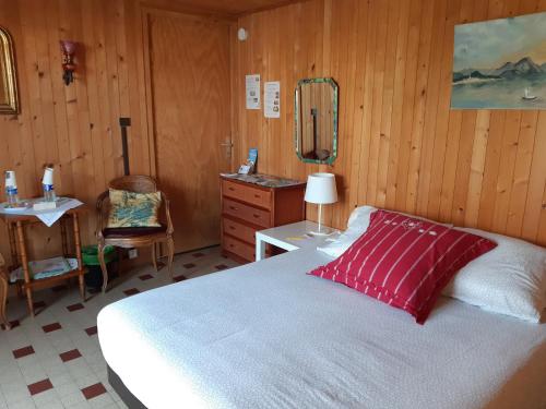 1 dormitorio con cama, tocador y espejo en Les Fougères, en Sévrier