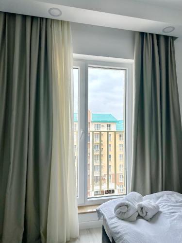 a bedroom with a bed and a large window at Double Studio B606 StayInn by Cosmopolis in Creţuleasca