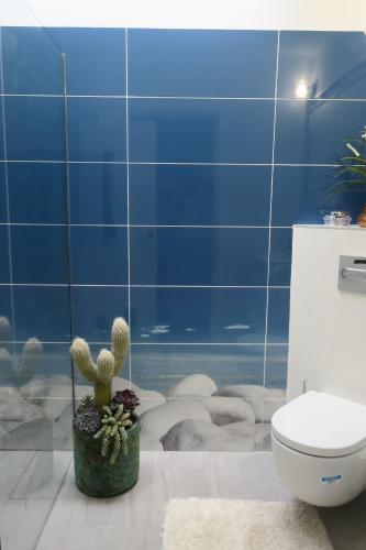 a bathroom with a cactus and a toilet and blue walls at Ankerplatz - casa Juseli - Ruhe und Erholung in Santa Úrsula