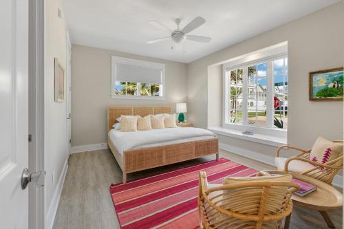 a bedroom with a bed and two windows at Surf Hut at Palmilla Beach in Port Aransas