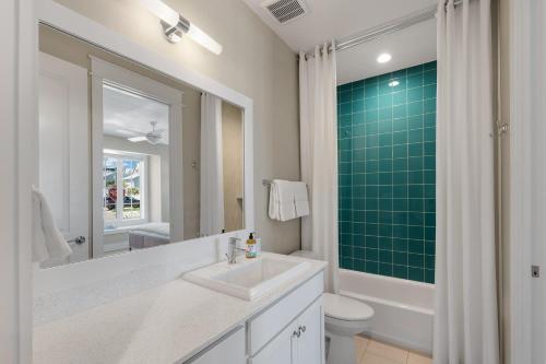 a bathroom with a sink and a toilet and a mirror at Surf Hut at Palmilla Beach in Port Aransas